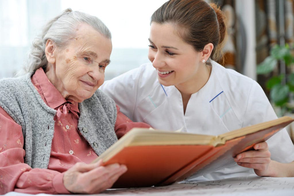 Nurse reading a book with an elderly patient