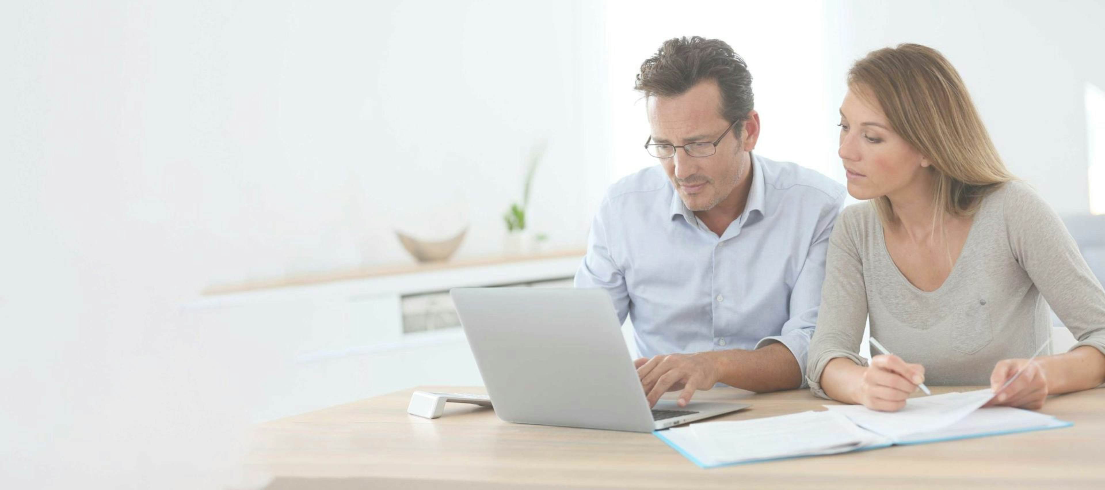 man and women sitting at desk working on a laptop