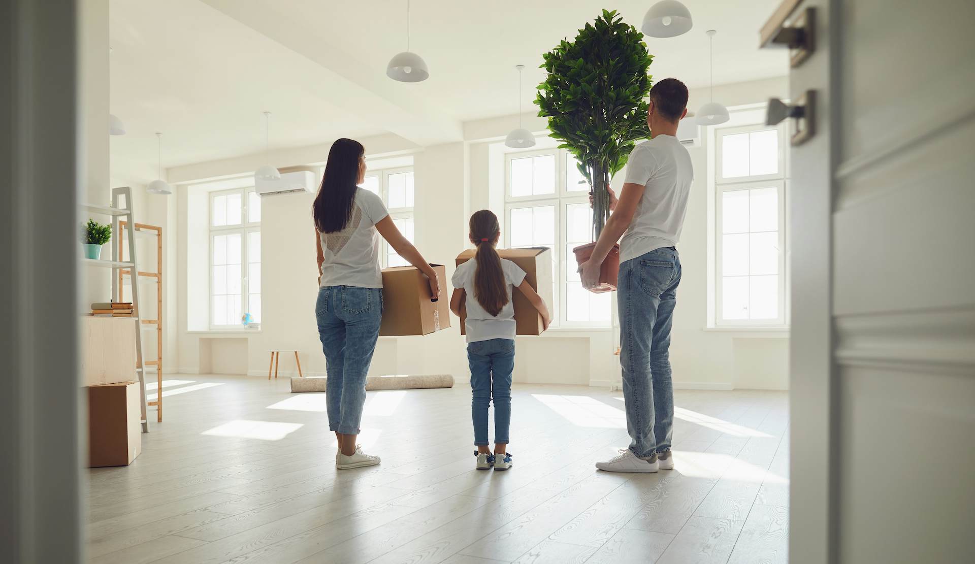 family holding boxes in empty home