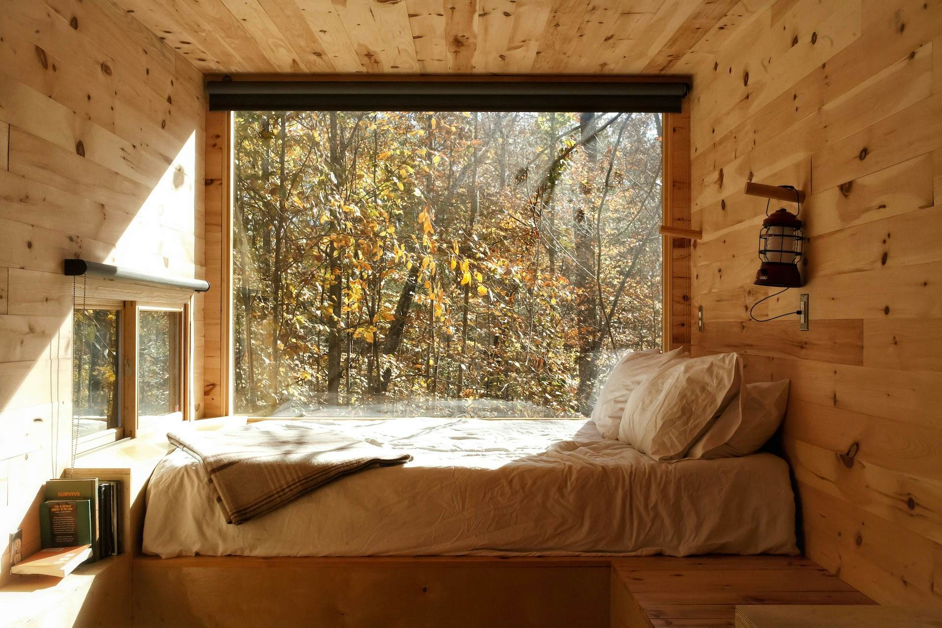 bed inside wooded room with a window looking outside