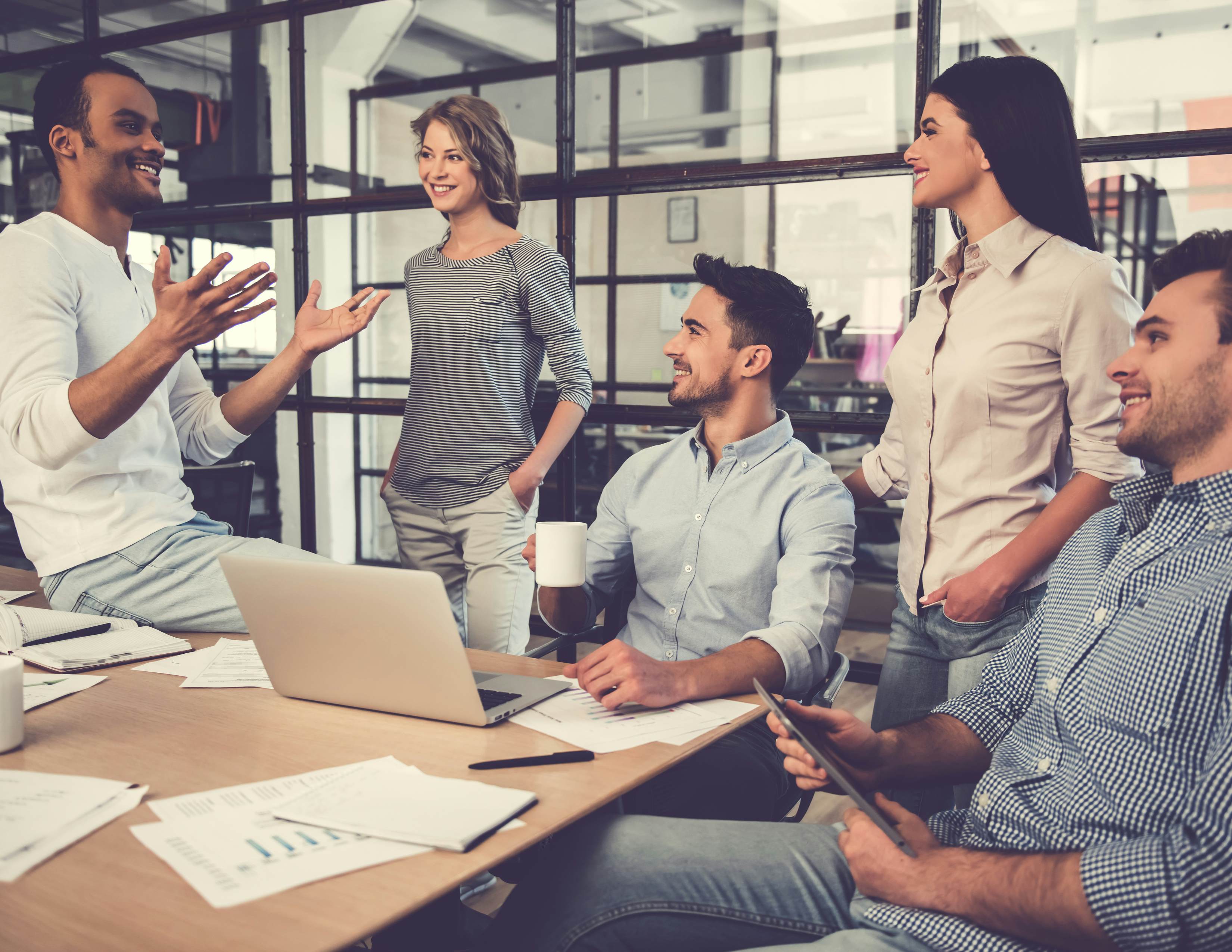 Group of employees working together at computer desk