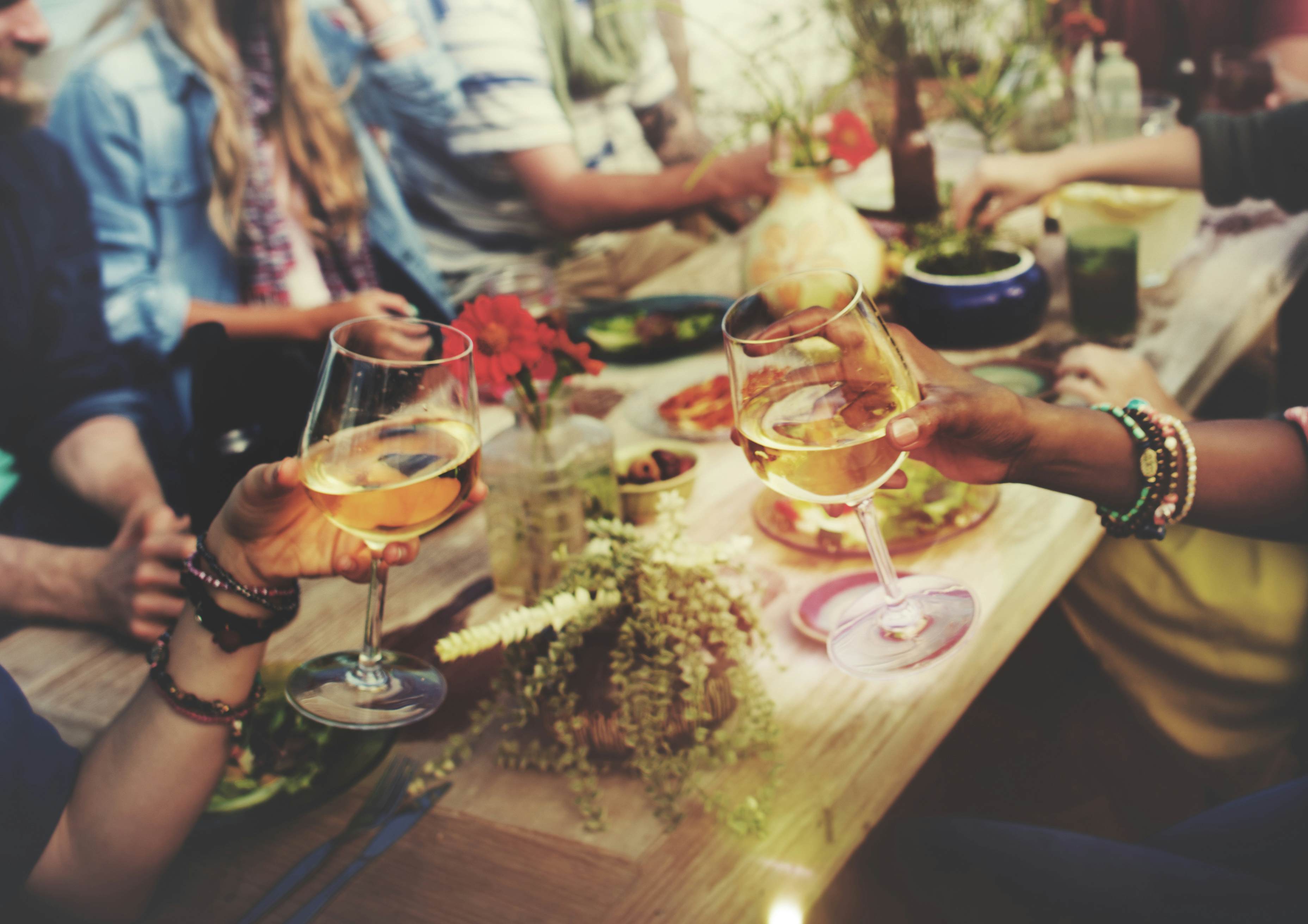 people gathered at dinner table drinking wine