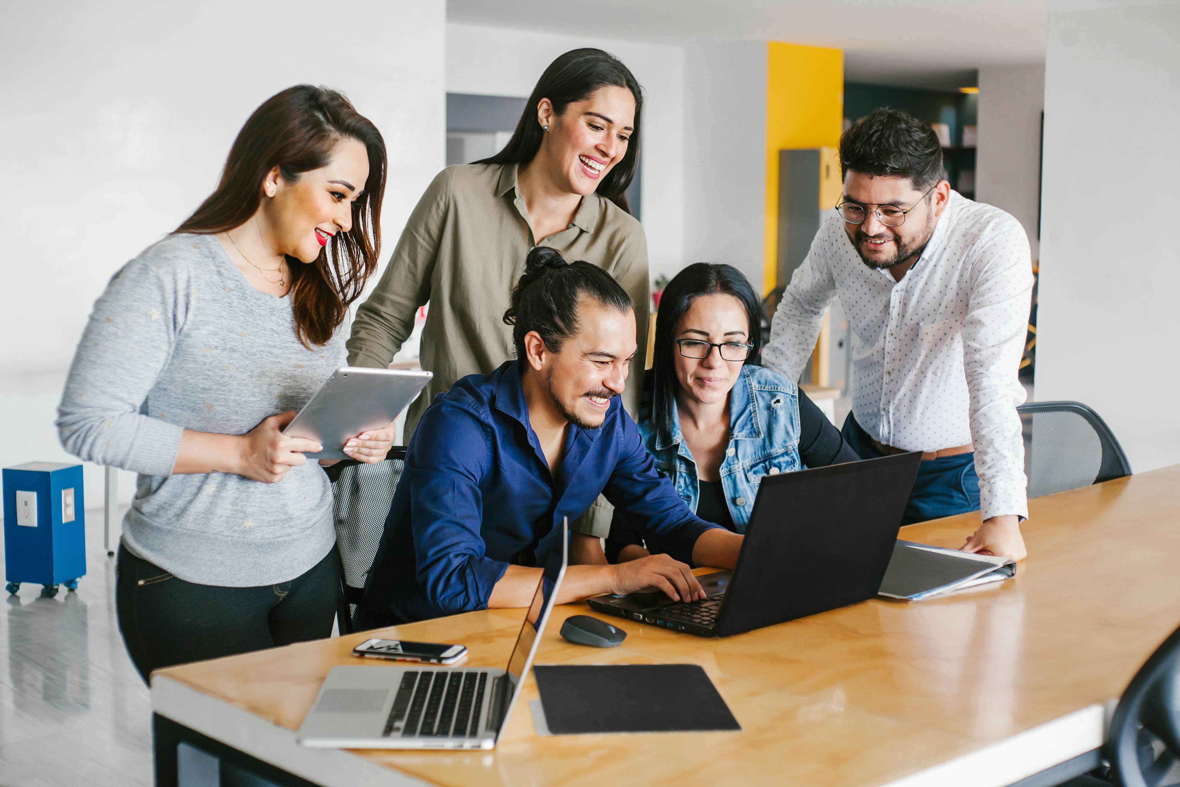 employees surrounding laptop