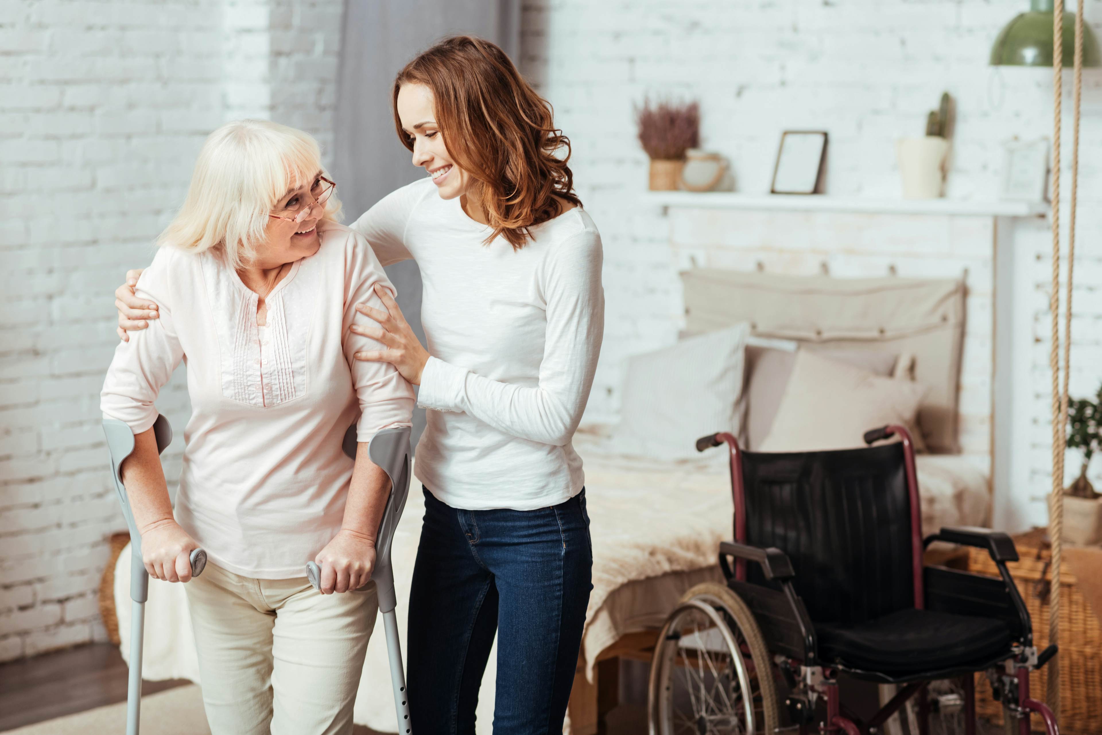 Elderly woman being helped by younger woman