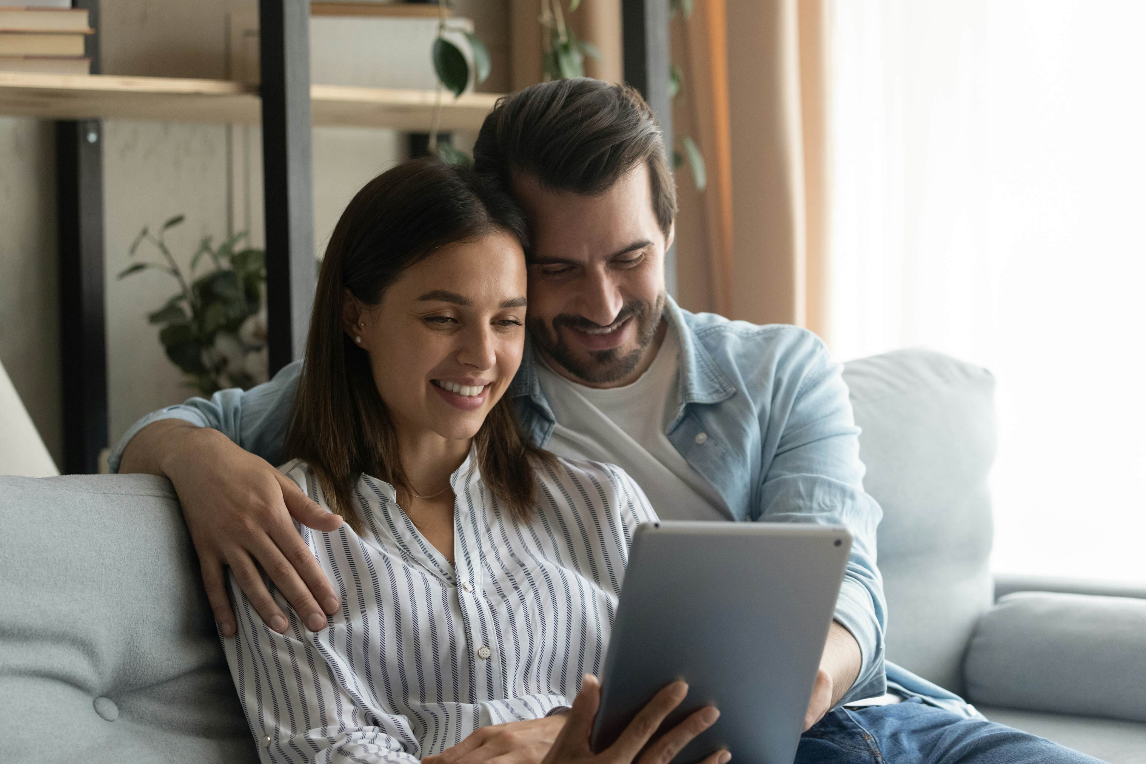 Couple looking at tablet smiling