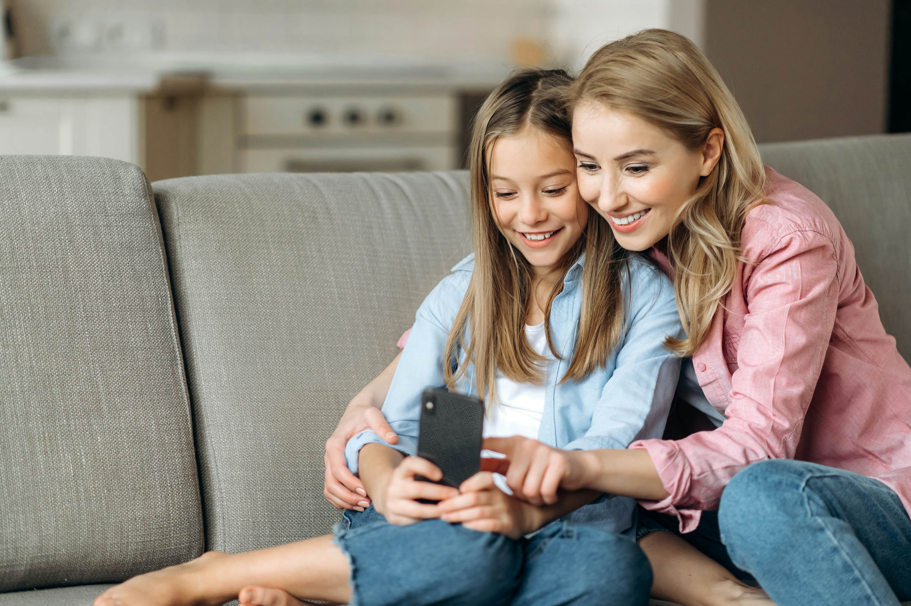 Mother and daughter smiling at phone