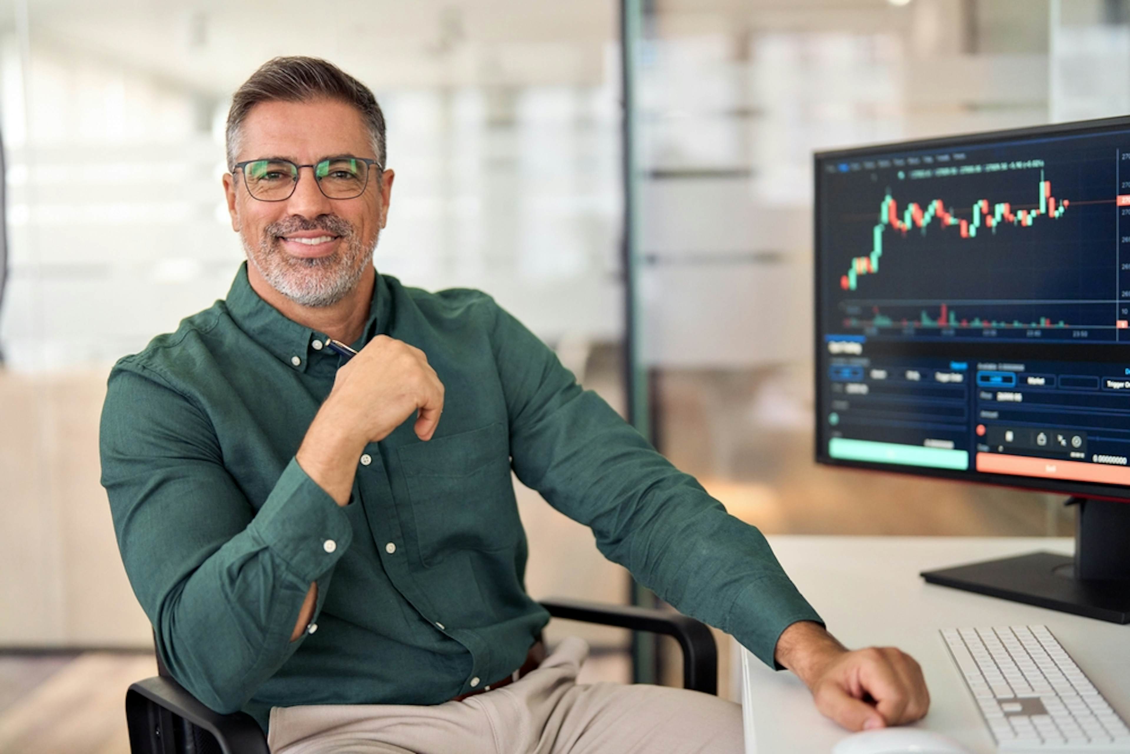 Business man analyzing investing chart happily